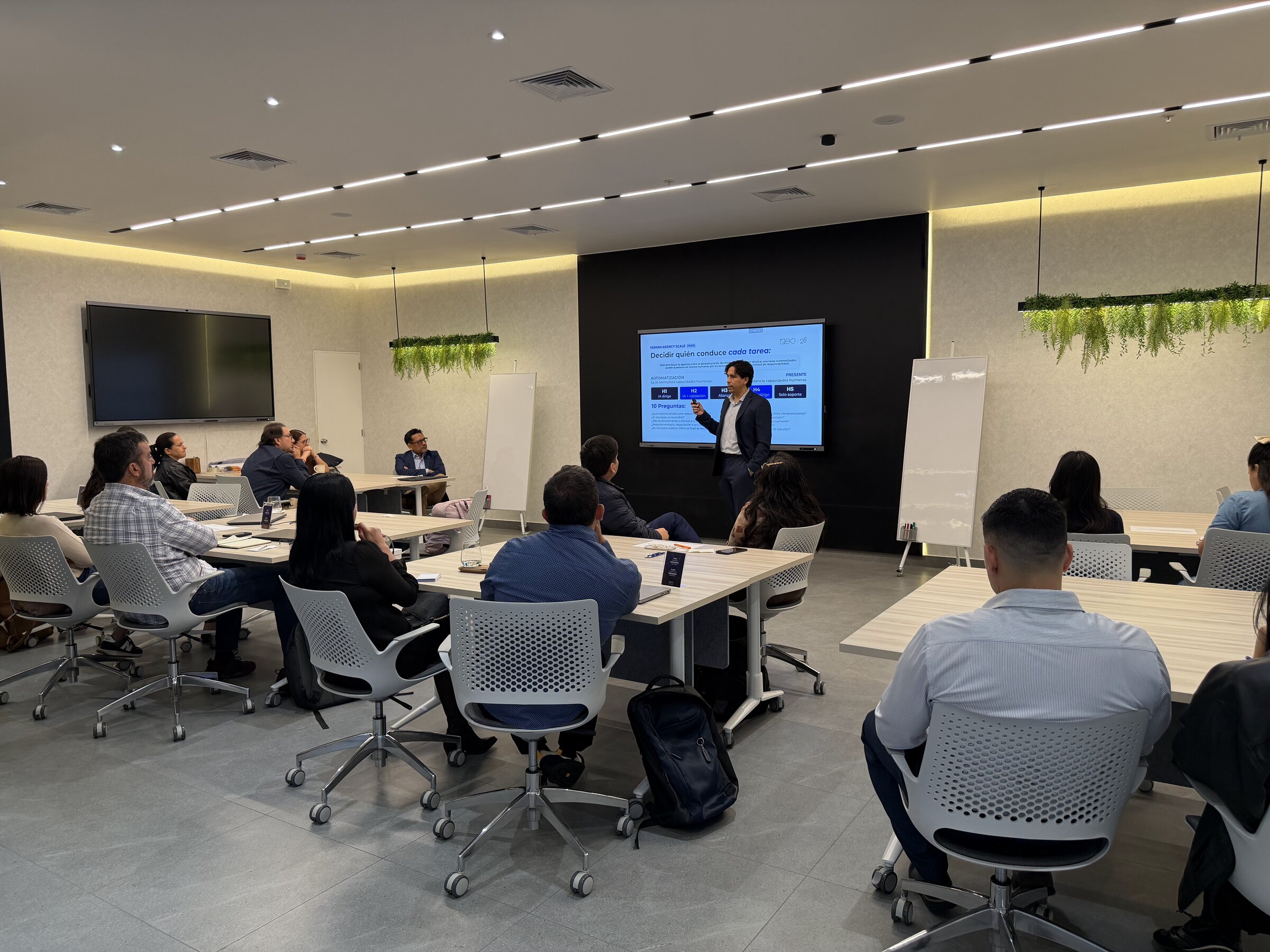Sesión de trabajo en el Neo AI Lab con los asistentes en mesas dispuestas en U